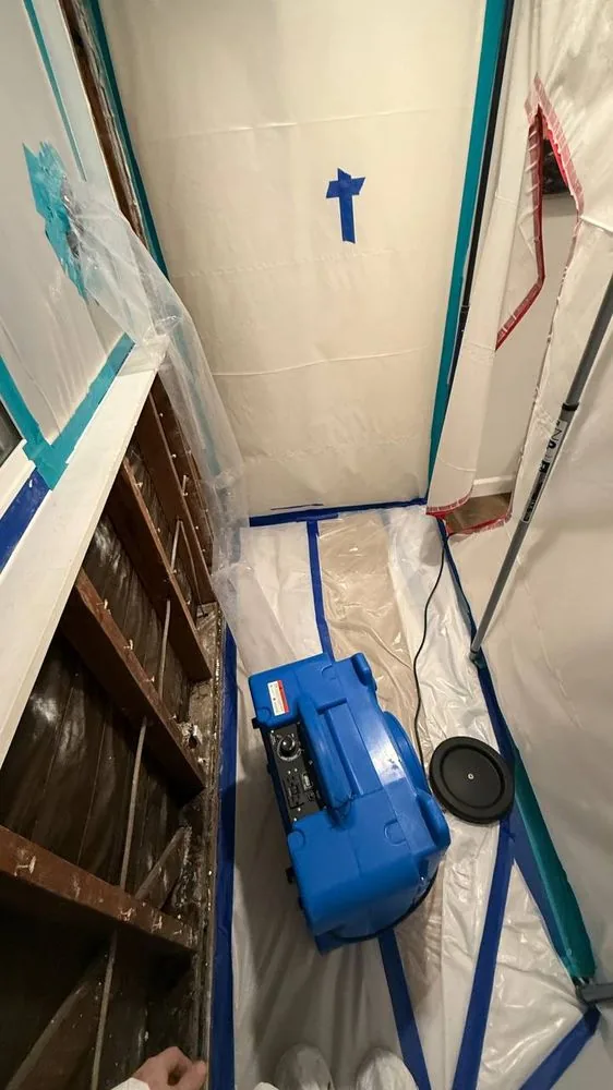 Air mover running inside containment, wall opened to dry the cavity